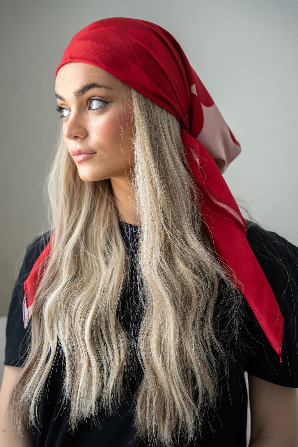 Flat lay of red and taupe head scarf with floral edge