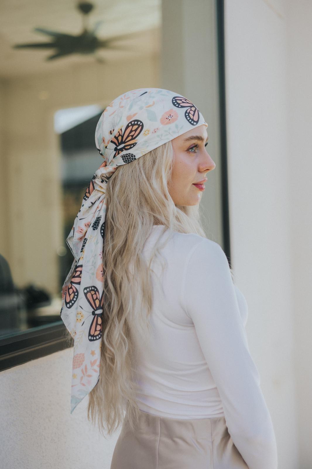 Set on a pale ivory backdrop, this lightweight silk scarf combines delicate pastels with bold monarch wing patterns, evoking a sense of nature’s grace and poetic charm.