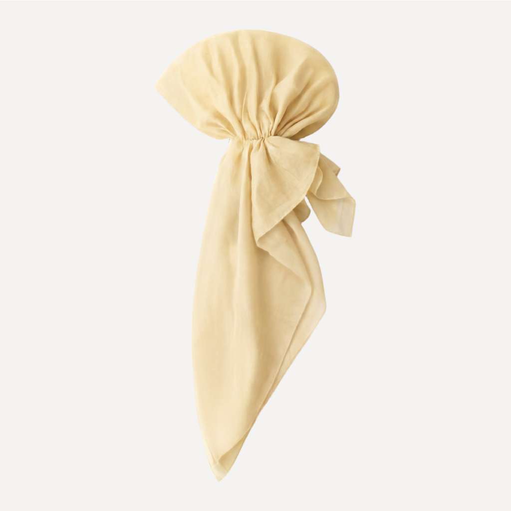 Butter Yellow Solid Head Scarf by TUK styled in a tied drape, showcasing soft pastel yellow fabric with a smooth, elegant finish.