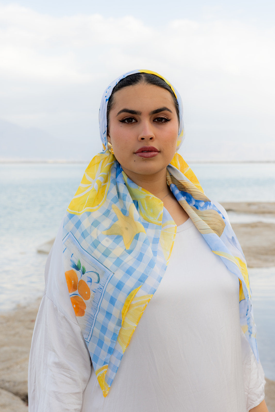 Ciao For Now Head Scarf by TUK with blue gingham, citrus and starfish print, styled by the sea for a chic coastal look.
