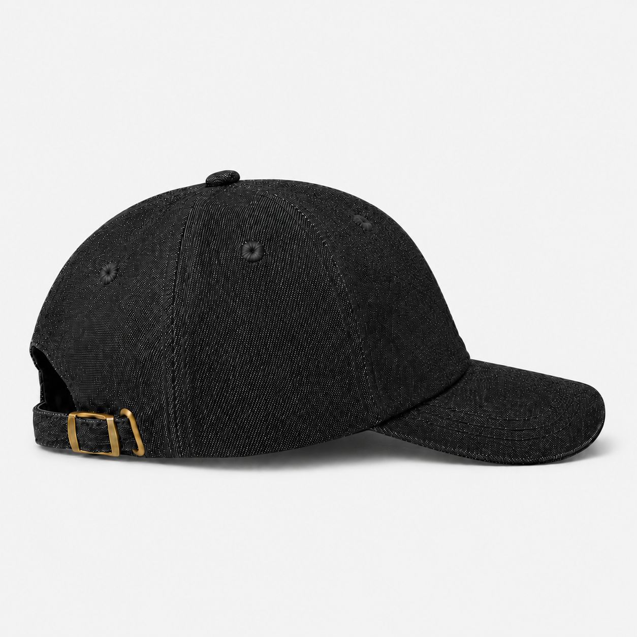 Side view of TUK Dark Wash Denim Cap in black denim featuring an adjustable strap, brass buckle, and curved brim design.