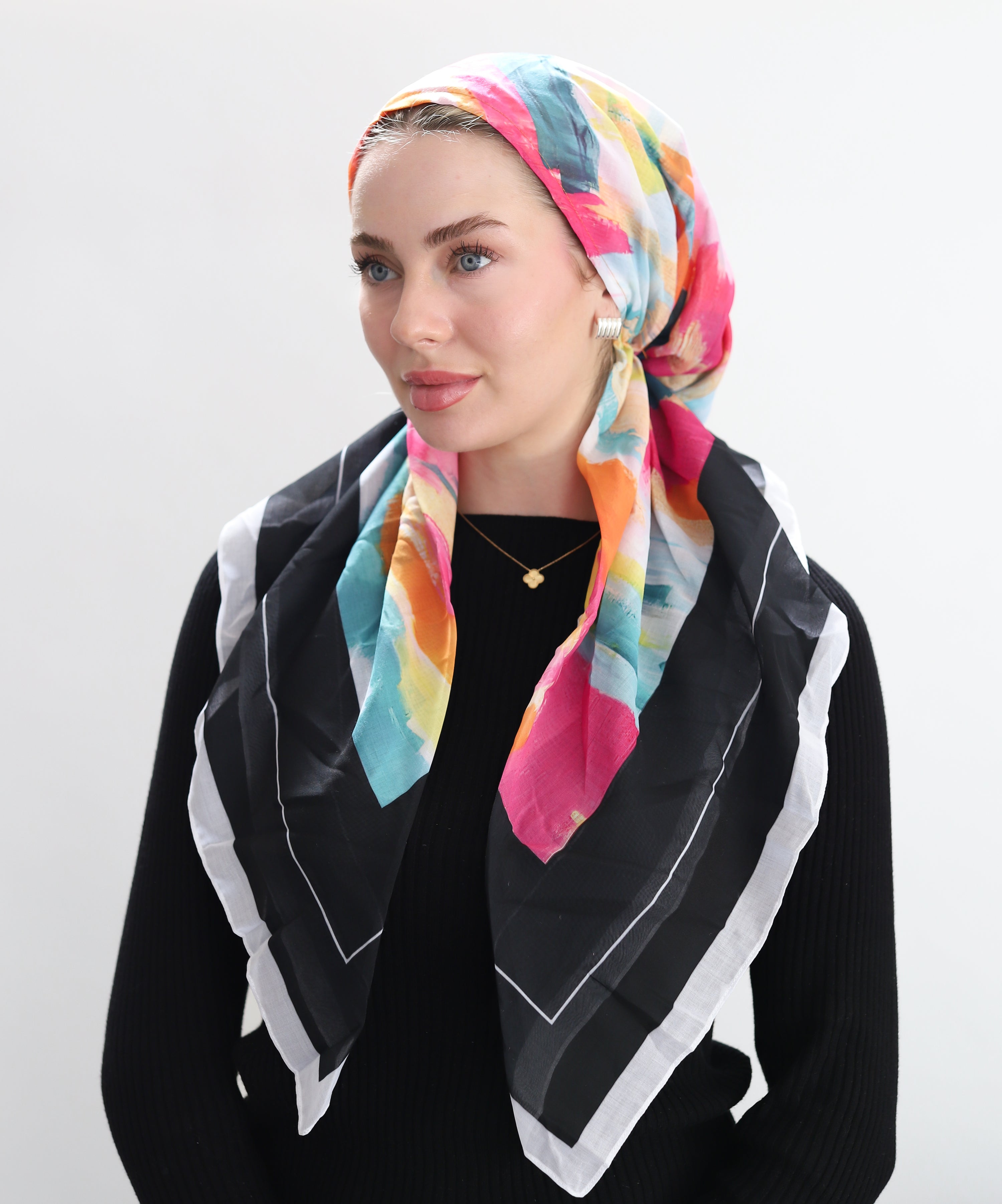 Woman wearing Electric Fee, its design features a high-energy abstract print with vibrant brushstrokes of hot pink, electric orange, teal, and golden yellow, creating a dynamic, painterly texture that feels both contemporary and expressive.