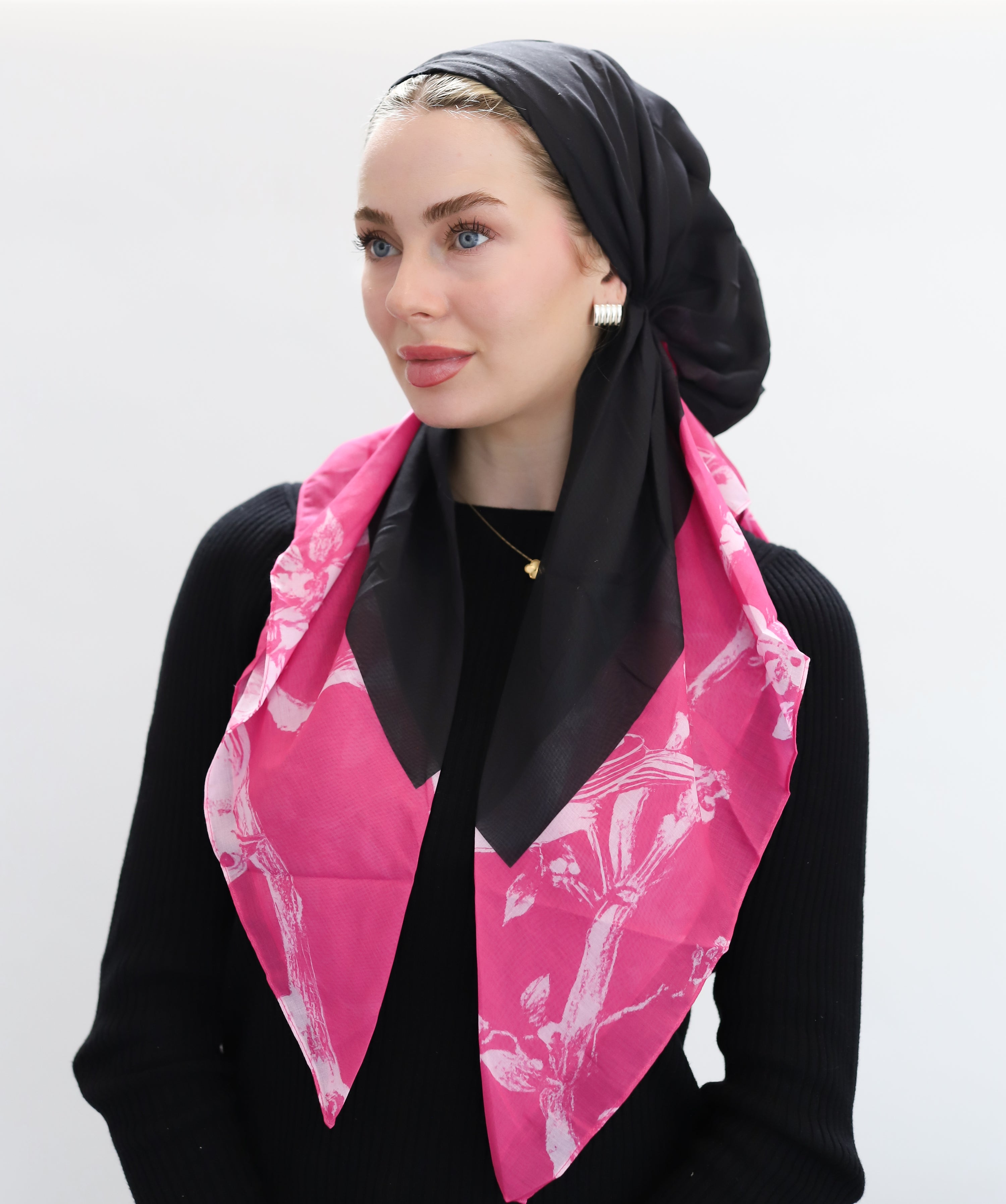 Woman wearing TUK Featherweight headscarf adds a playful twist with its hot pink illustrated border and clean black center. The bird artwork gives it a soft, almost vintage charm. elegance.