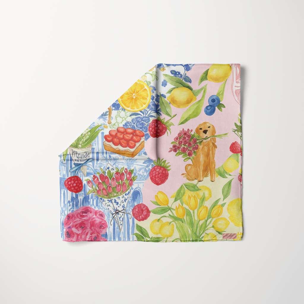 TUK Fleurs & Citrons head scarf with vibrant lemons, berries, florals, and playful dog illustration in colorful patchwork design.