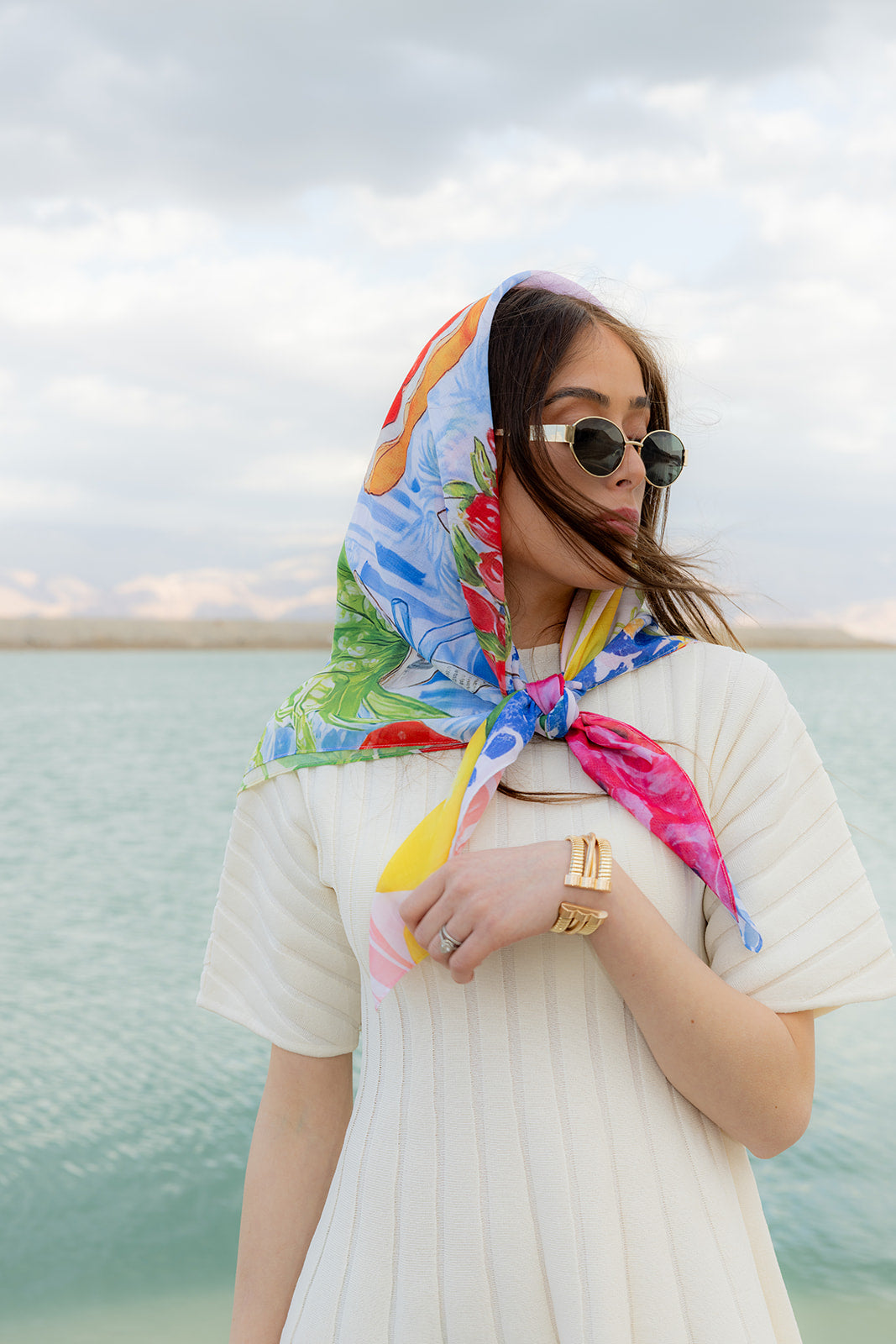 TUK Fleurs & Citrons Silk Bandana with vibrant floral and citrus print worn as a chic headscarf by the waterfront.