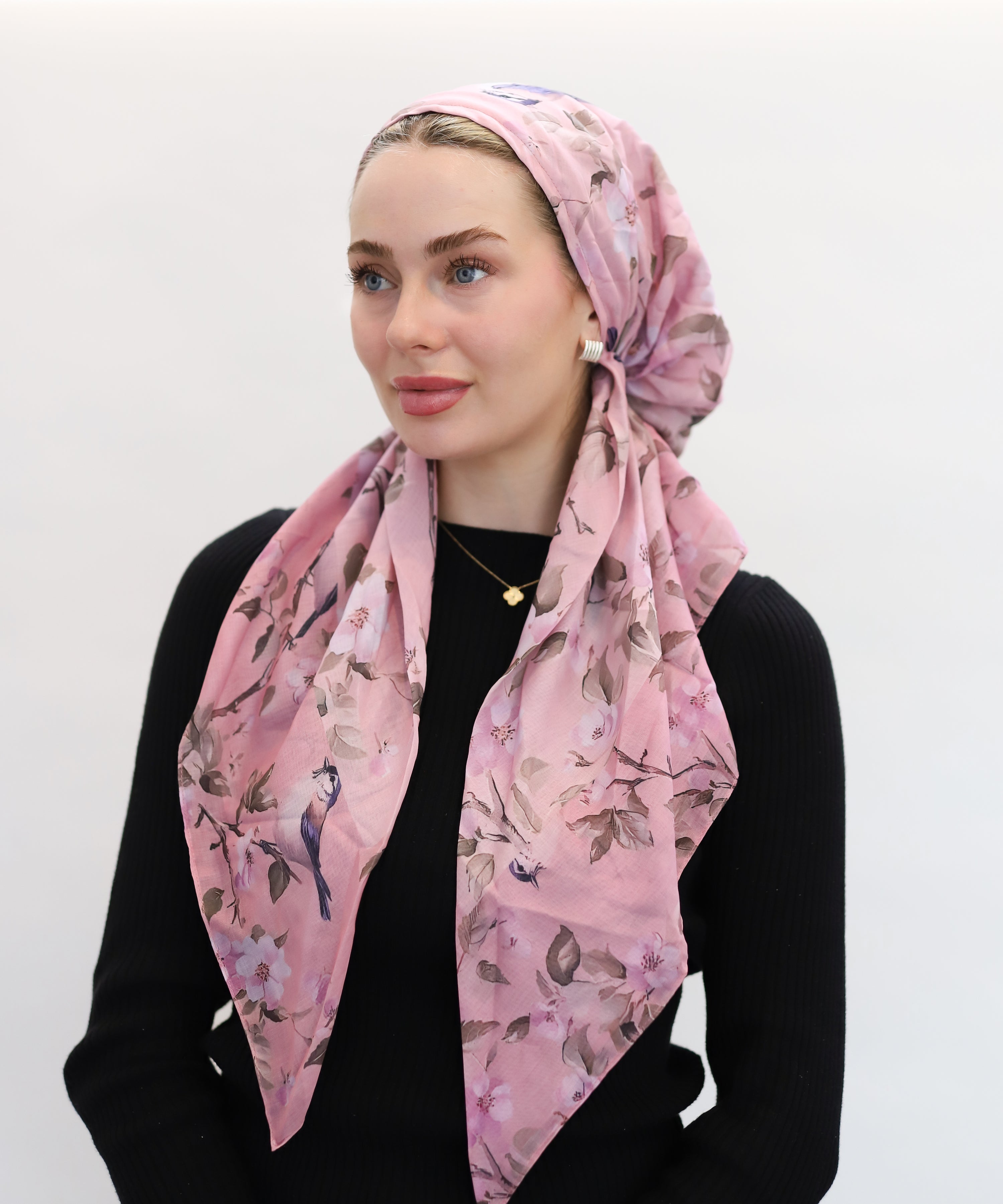 Woman wearing a pink floral headscarf by TUK on a white background