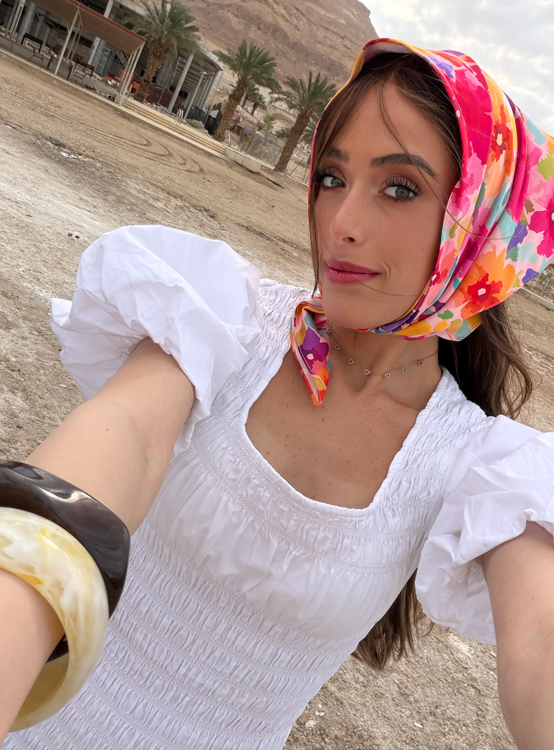 Model wearing TUK Flower Hour Silk Scarf, vibrant floral silk headscarf styled outdoors, lightweight luxury fashion accessory.