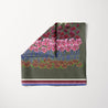 TUK Garden Variety Head Scarf with layered floral design in red, pink, blue, and earthy tones on olive green with striped borders.