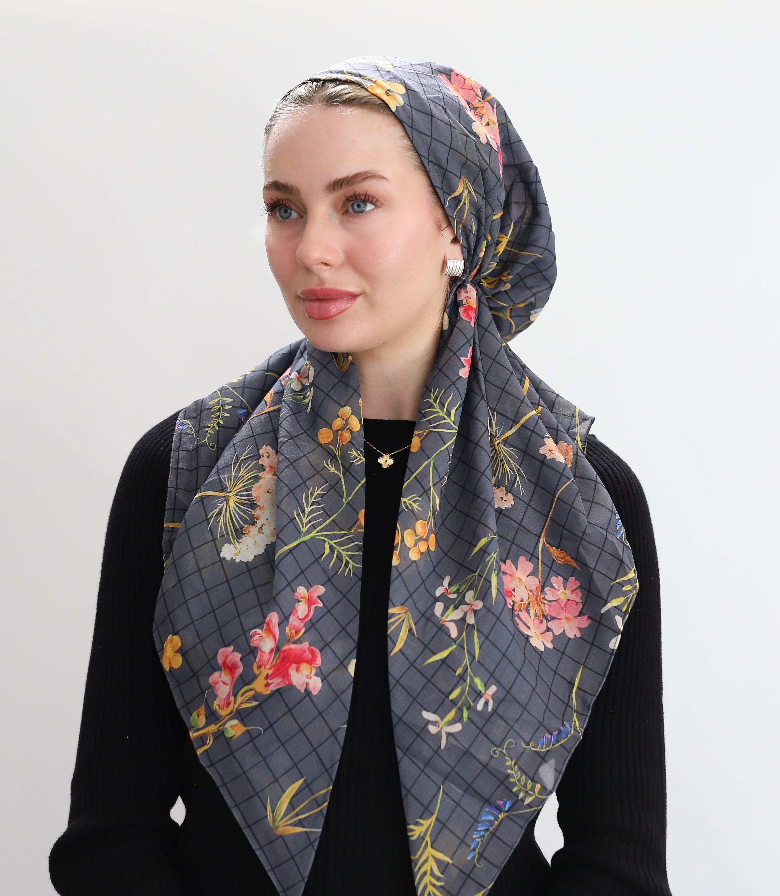 Woman wearing a TUK  floral patterned headscarf Gridwork on a white background