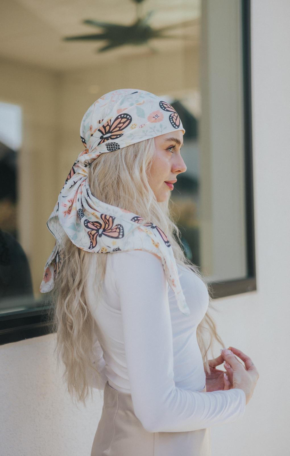 Float into femininity with the Winged Whispers Silk Headscarf—a romantic accessory adorned with soft coral florals and elegant butterfly motifs.