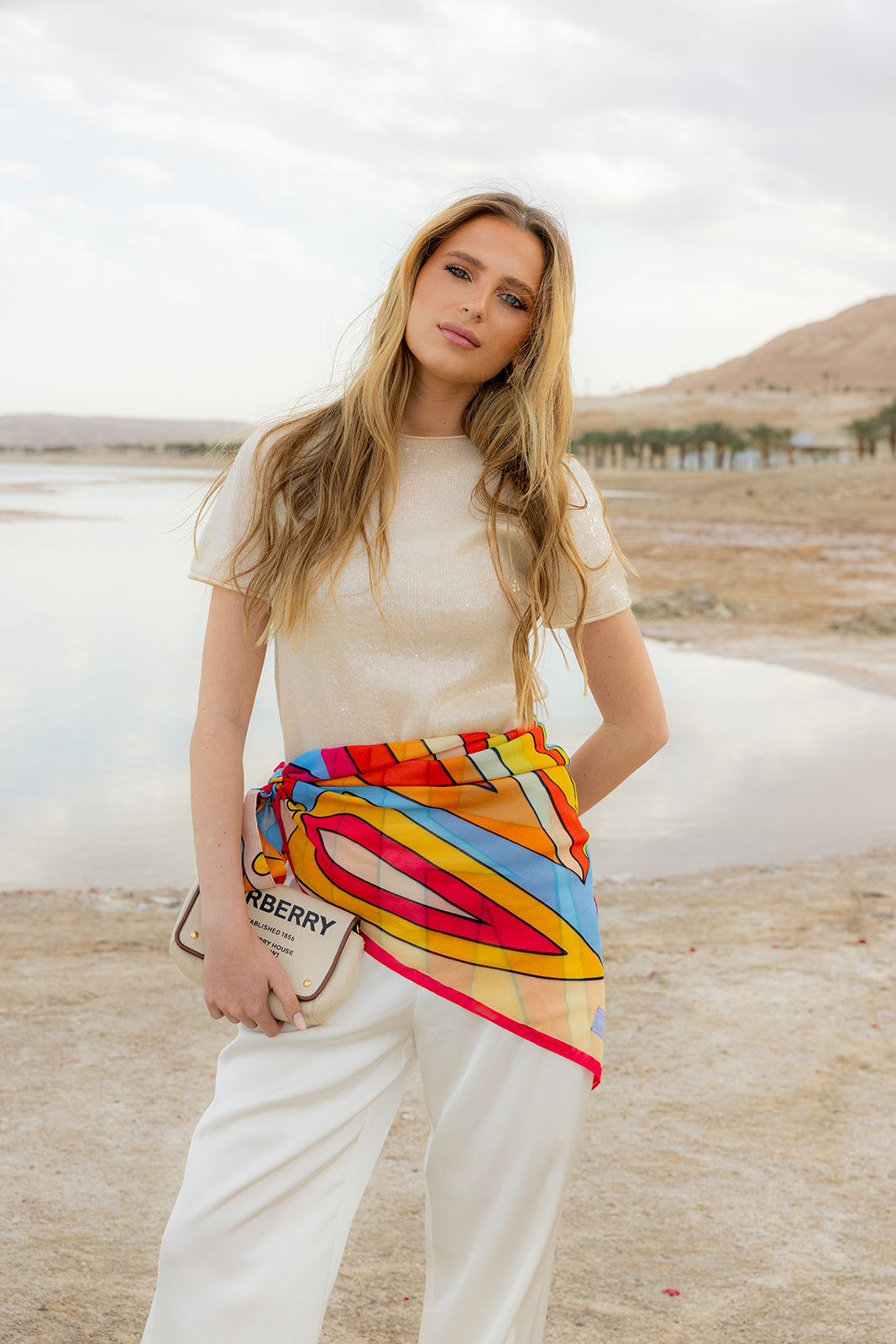 TUK Hot Line Silk Bandana in a vibrant geometric print, styled as a waist scarf with a chic coastal resort outfit.