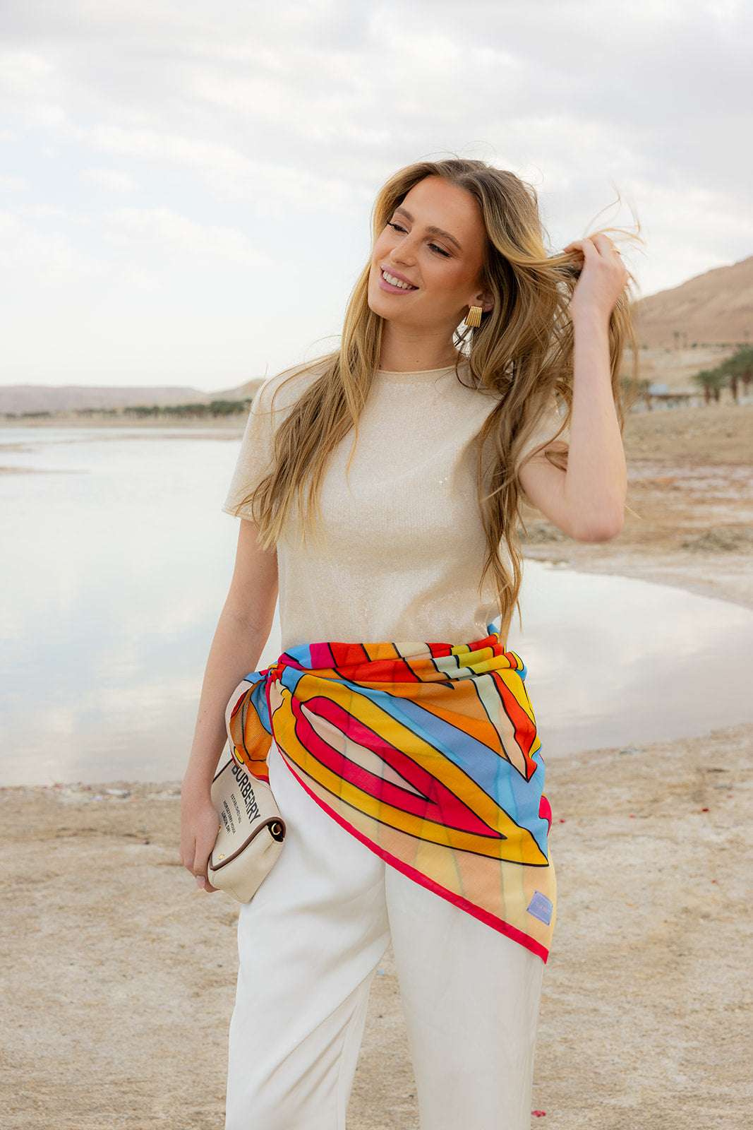 TUK Hot Line Silk Bandana with bold geometric print, styled as a waist scarf for a colorful, elegant coastal look.
