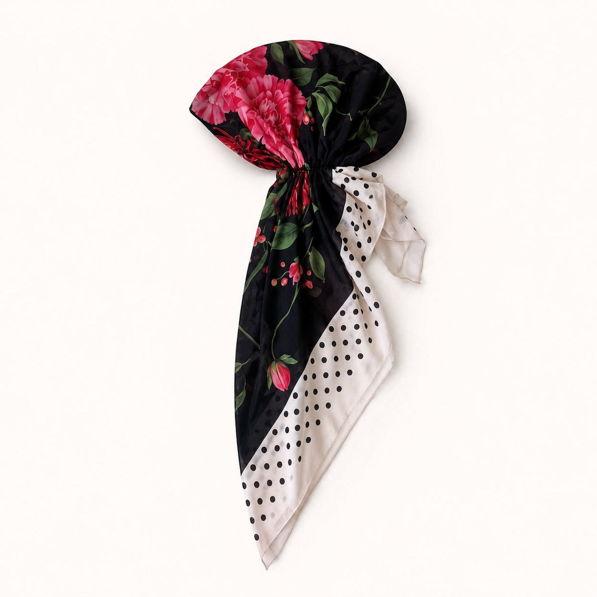 TUK In Full Swing Head Scarf styled in a knot, featuring vibrant pink florals on black with a cream polka dot border.