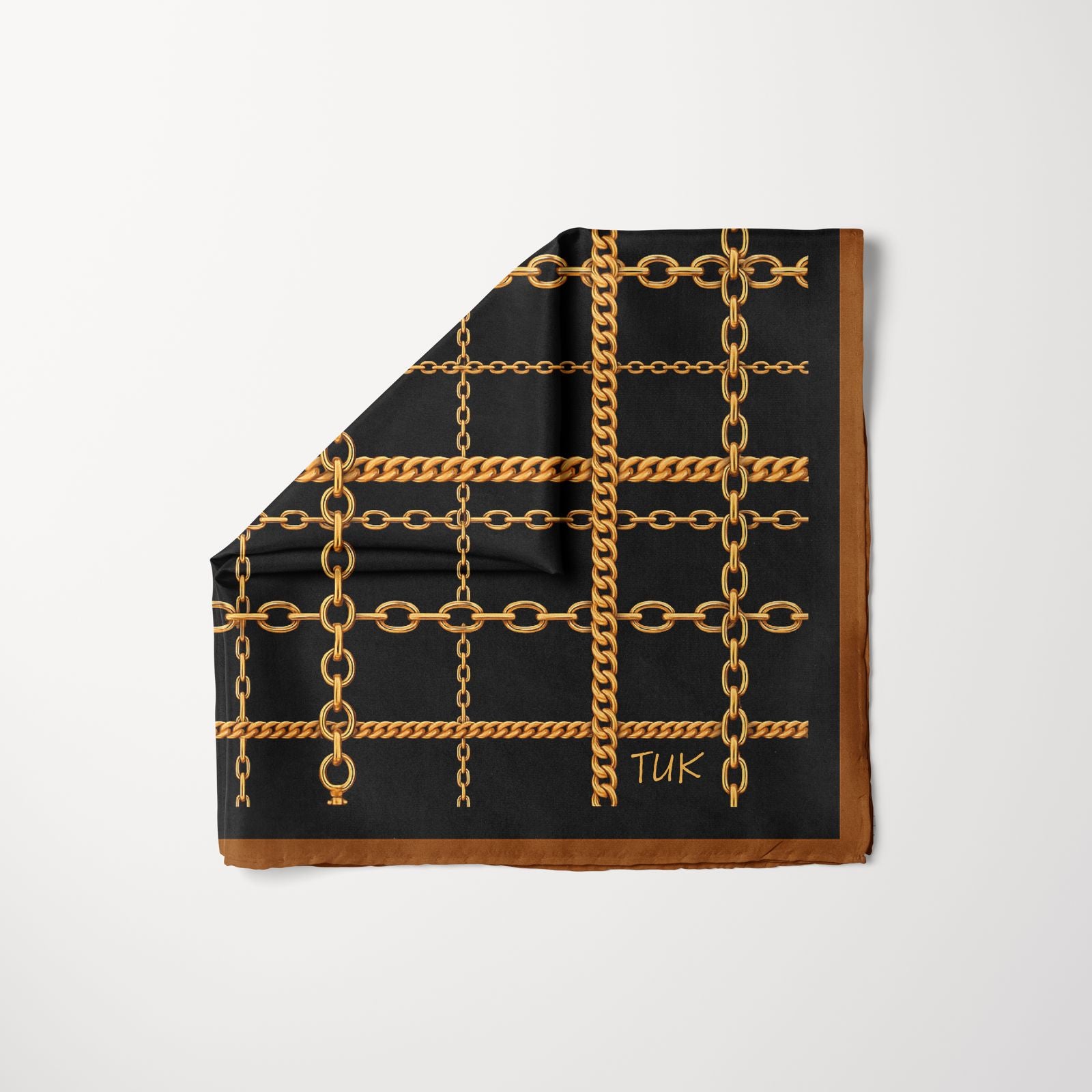 TUK Ironed Out Pre-tied Head Scarf featuring a bold gold chain grid pattern on black fabric with a brown border for a chic, timeless look.