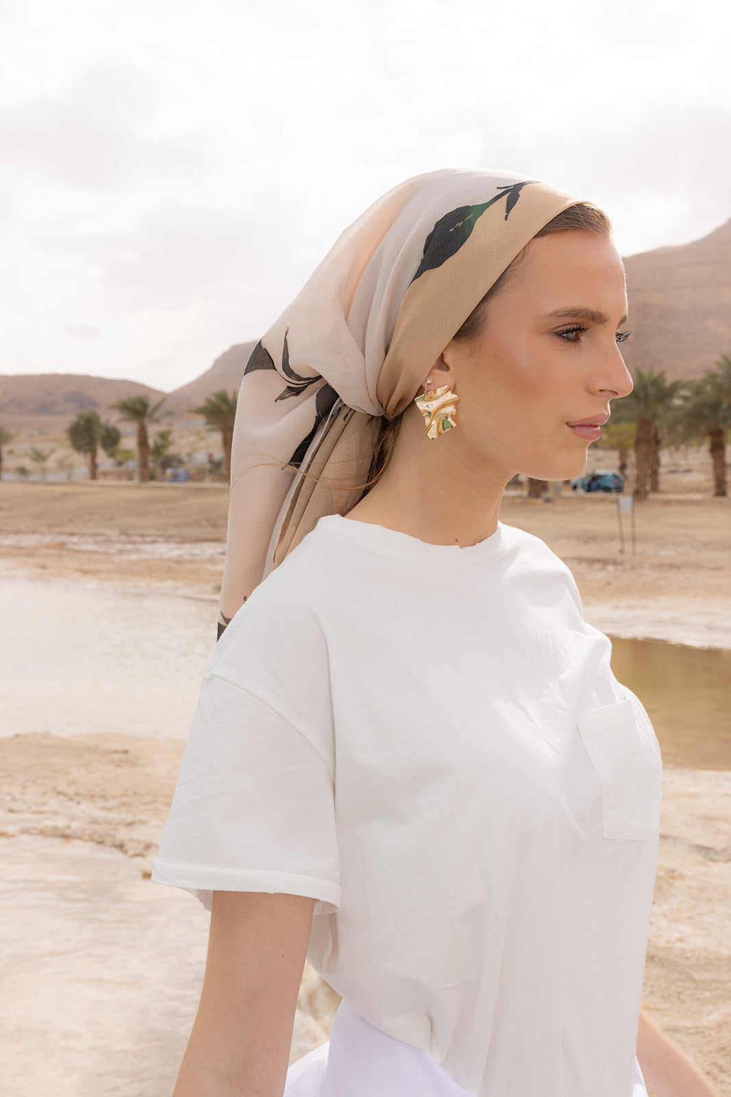 Love, Muted Head Scarf by Tie Ur Knot styled in a soft neutral print, worn elegantly outdoors with modern resort fashion.