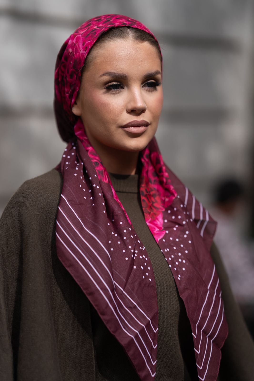 Woman wearing TUK Marooned headscarf is berry-tone perfection. Deep maroons, bright pinks, and a modern dotted border that makes it feel clean, fresh, and very “I put this on in two seconds and still look incredible.”