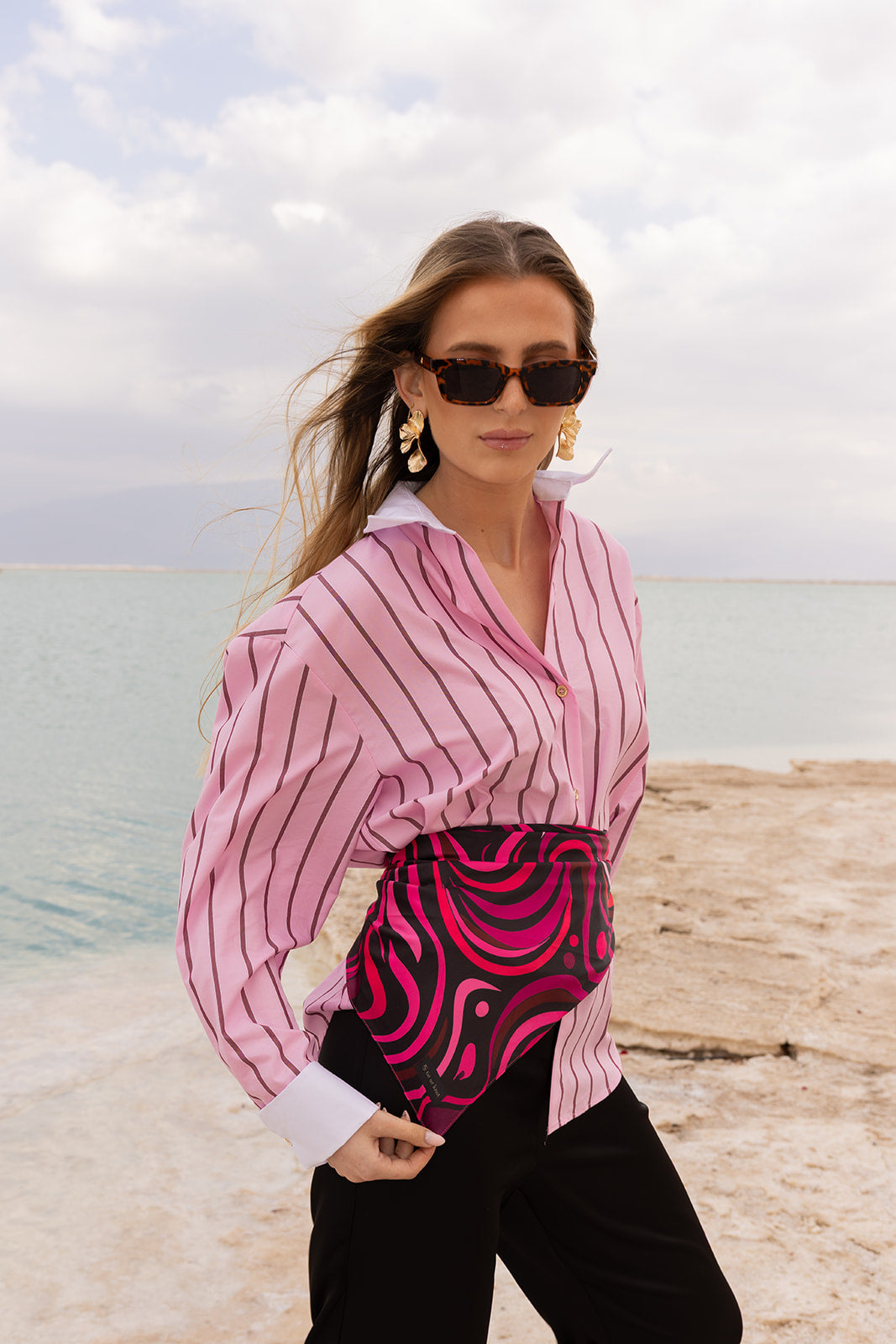 Mind Over Matter Silk Bandana by TUK styled as a waist sash, featuring bold pink abstract patterns for a chic look.