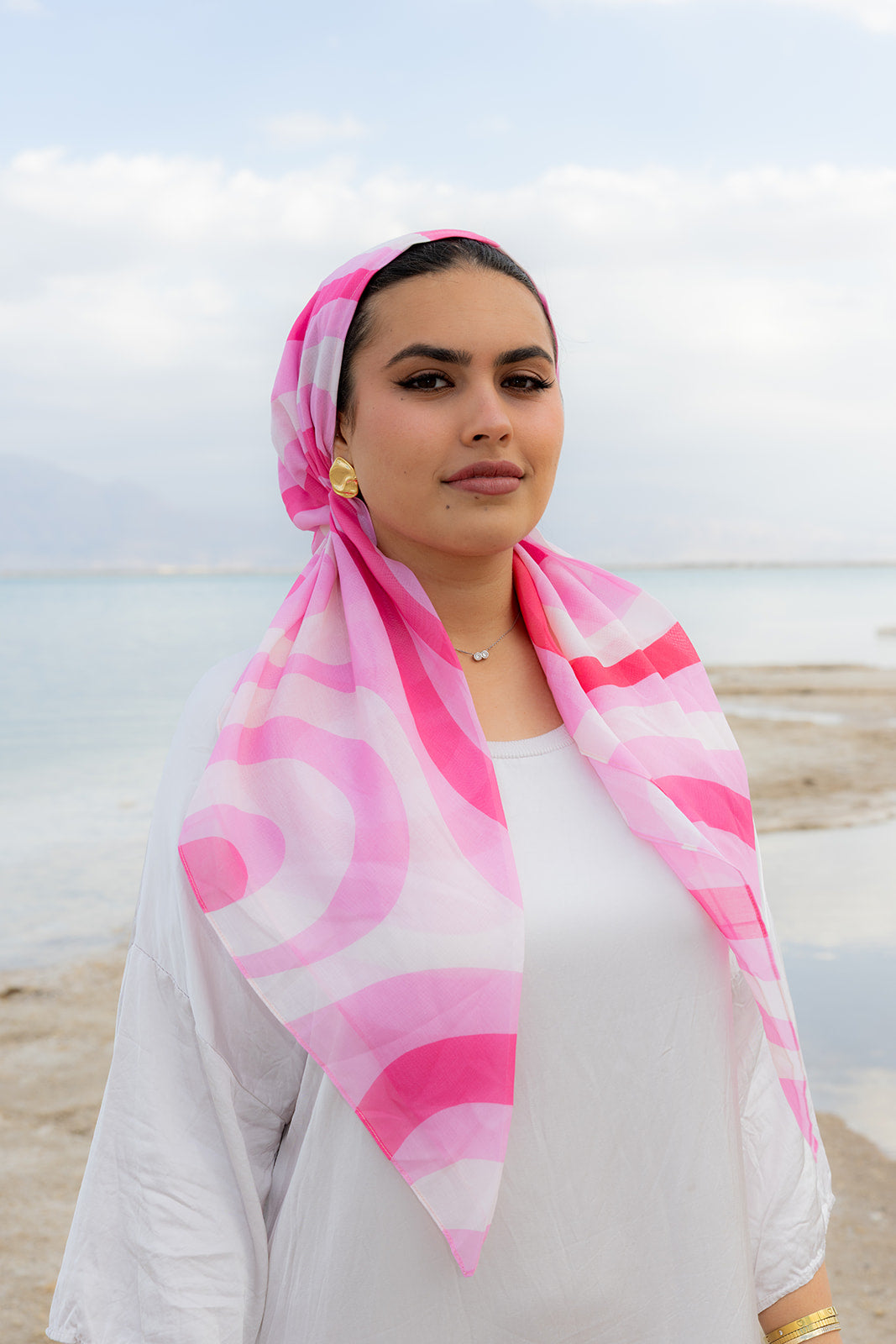 Pretty In Motion Head Scarf by TUK in vibrant pink and white swirl print, lightweight chiffon headscarf styled by the seaside.