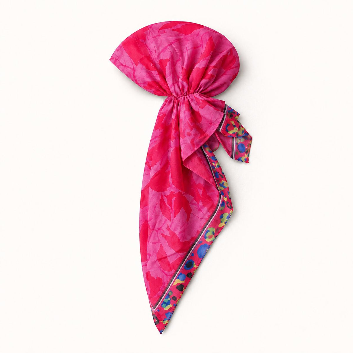 TUK Prima Ballerina Head Scarf styled in a bow tie with flowing tails, featuring a pink and red floral print and colorful trim.