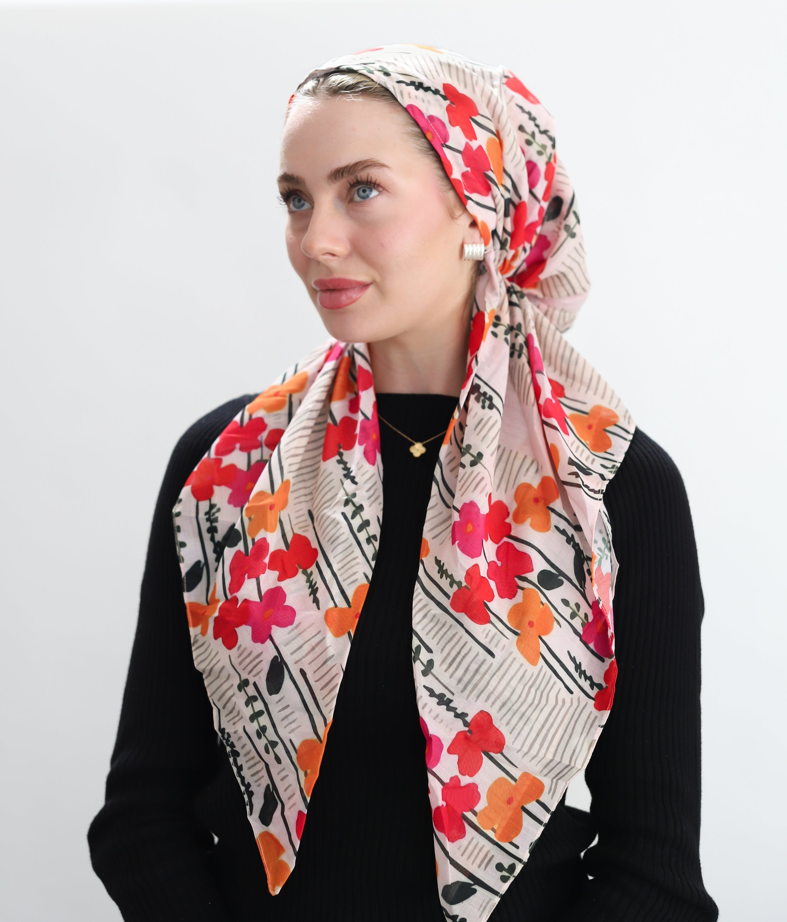 Woman wearing a colorful floral headscarf on a white background