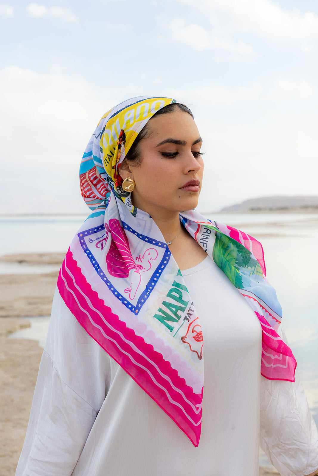 Return To Sender Head Scarf by TUK featuring vibrant Italy-inspired travel illustrations, styled as a chic women's fashion head scarf.