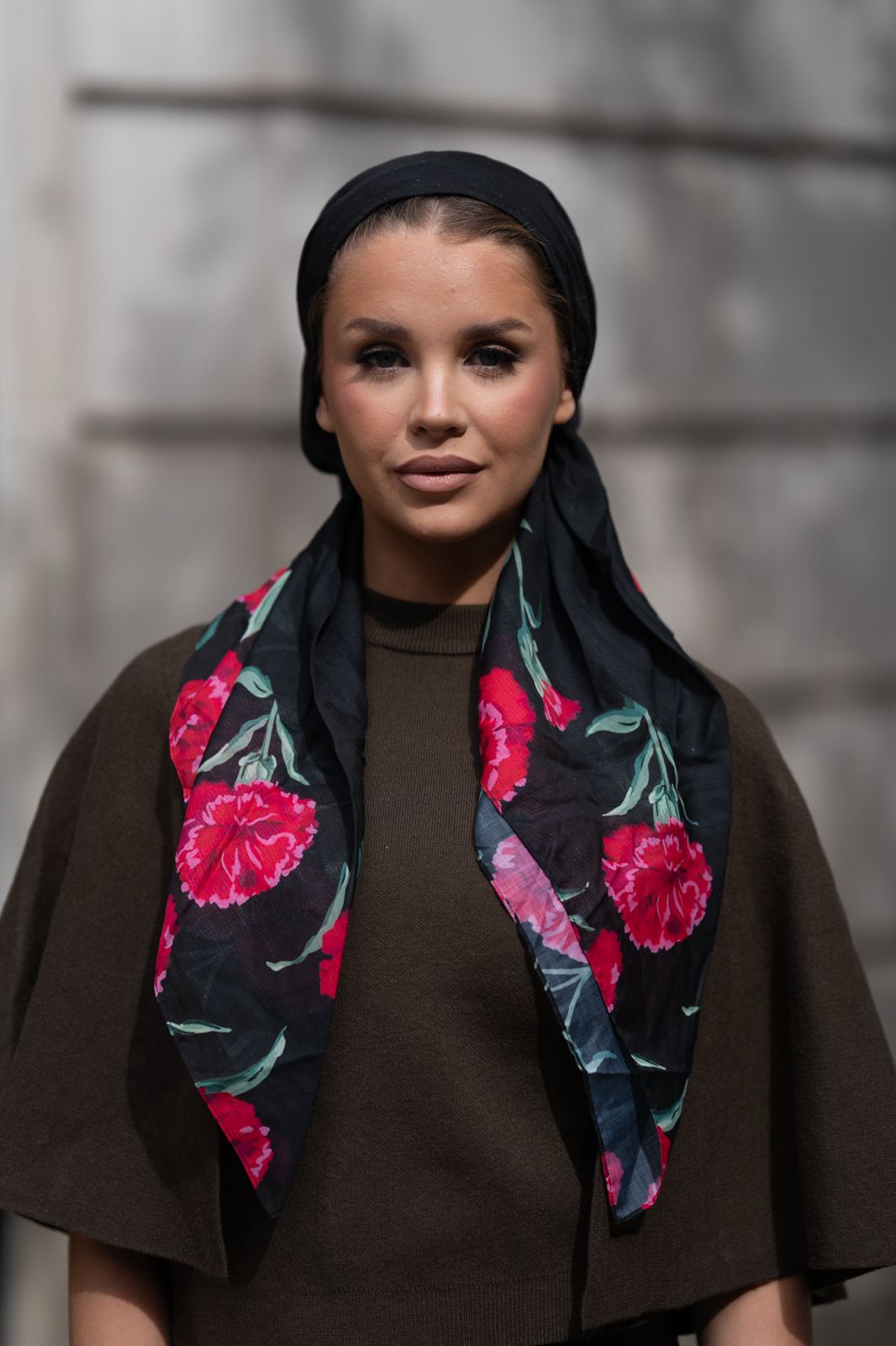 Woman wearing a floral scarf with a dark background
