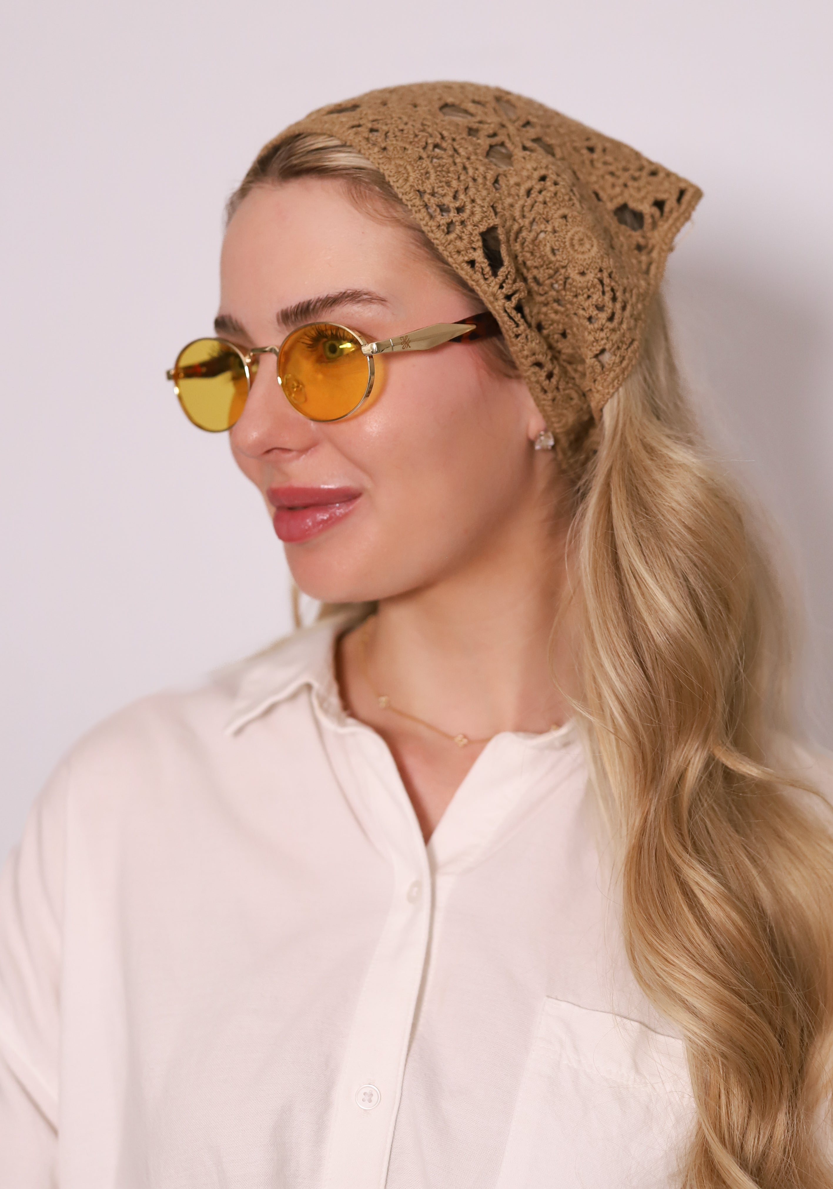 Sola Sunglasses by TUK featuring amber-tinted lenses, gold frames, and a boho crochet headscarf for chic style.