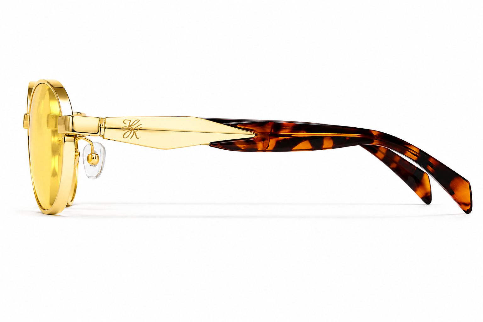 Side view of TUK Sola Sunglasses featuring yellow-tinted lenses, gold metal frame, and tortoise shell temples with luxe details.