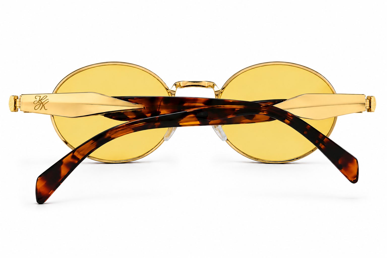 Back view of TUK Sola Sunglasses showcasing yellow-tinted lenses, gold metal frame, and tortoise temples with premium detailing.