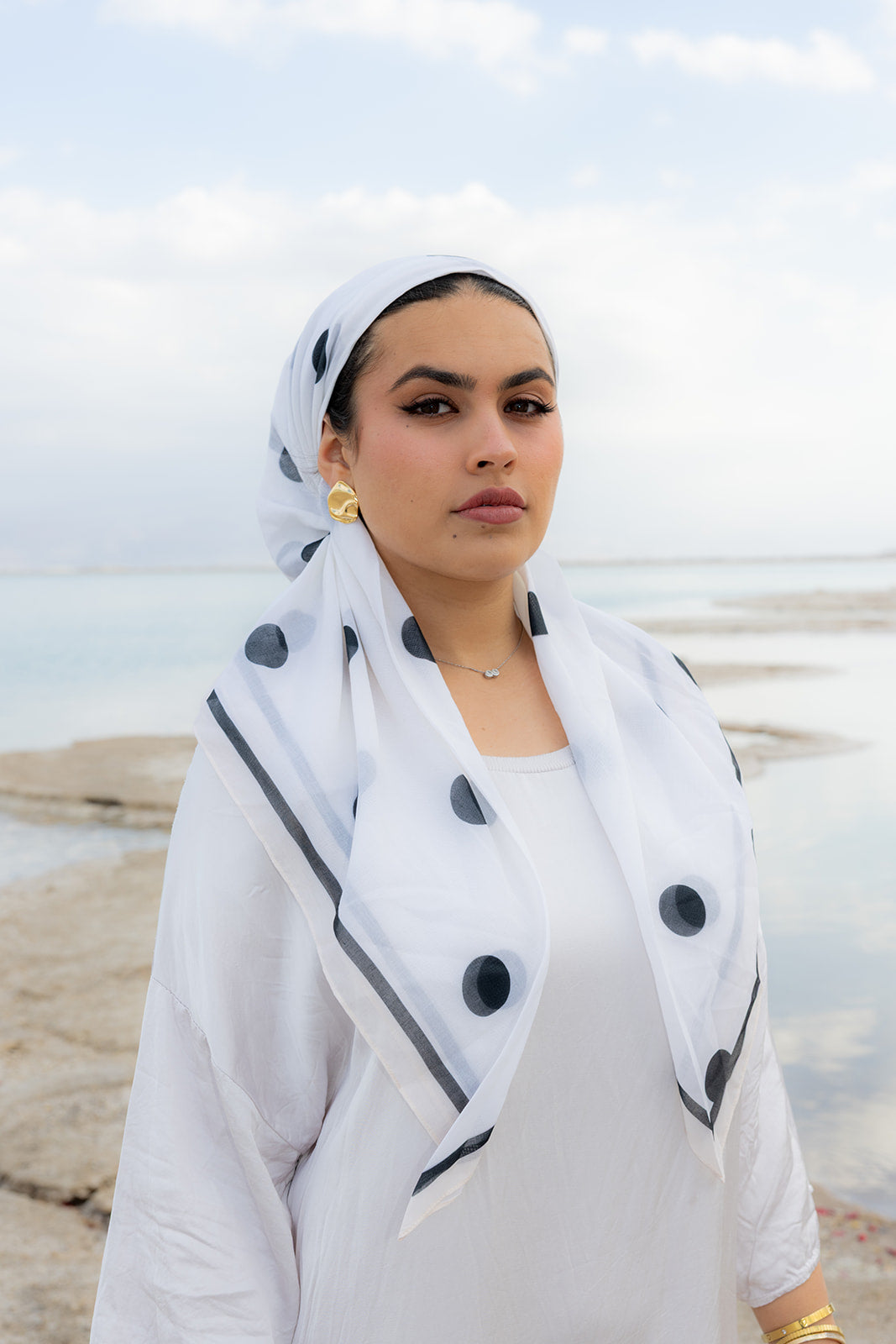 Spot On Head Scarf by TUK in white chiffon with bold black polka dots, elegantly styled by the waterfront.