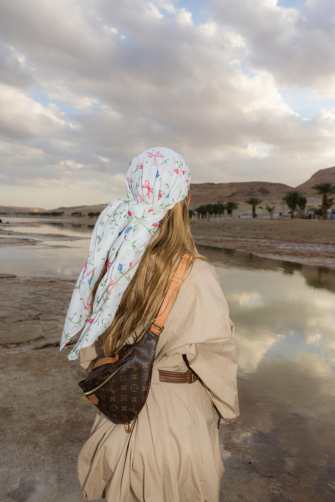 TUK Spring Thing Head Scarf crochet bandana with soft floral print, tied at the back and styled in a scenic coastal landscape.
