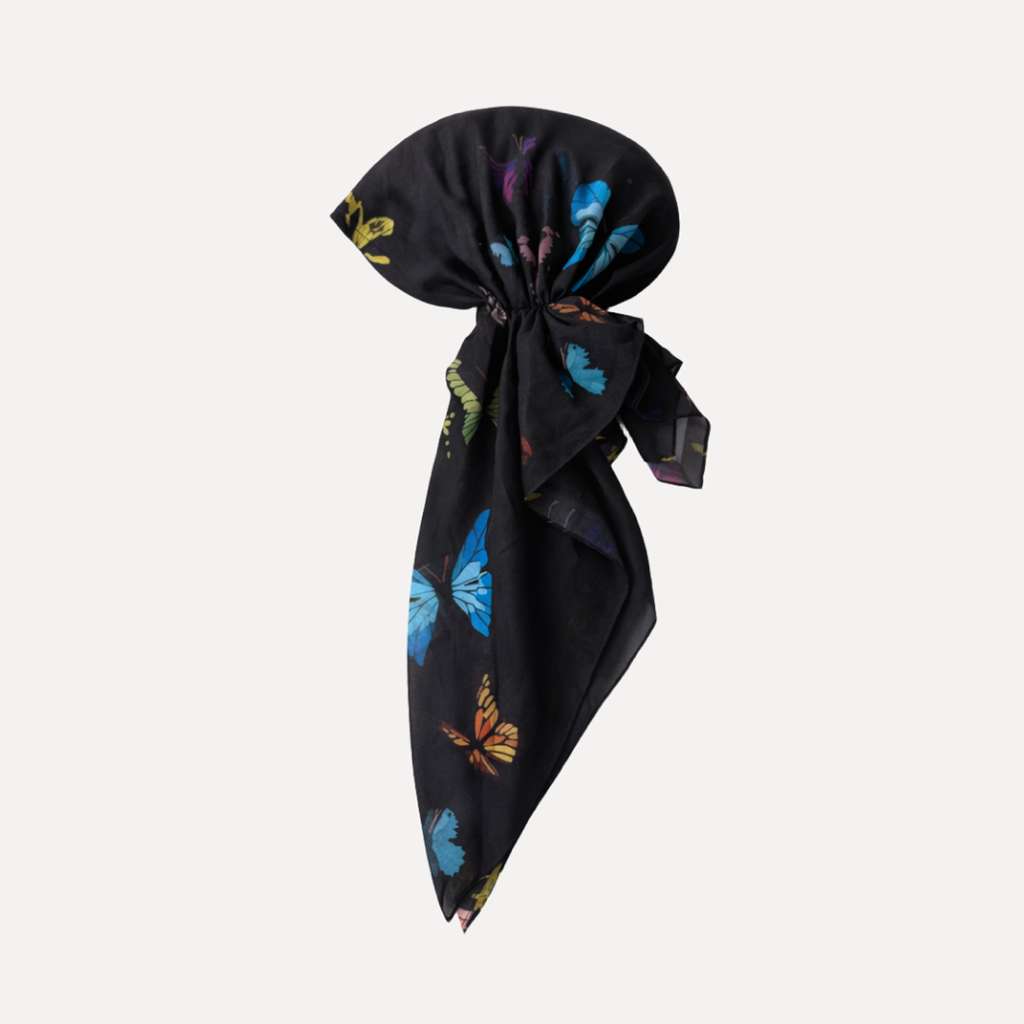 Black headscarf with colorful butterfly print, pre-tied design by TUK, called The Night Shift Pre Tie, stylish satin head wrap for hair protection.