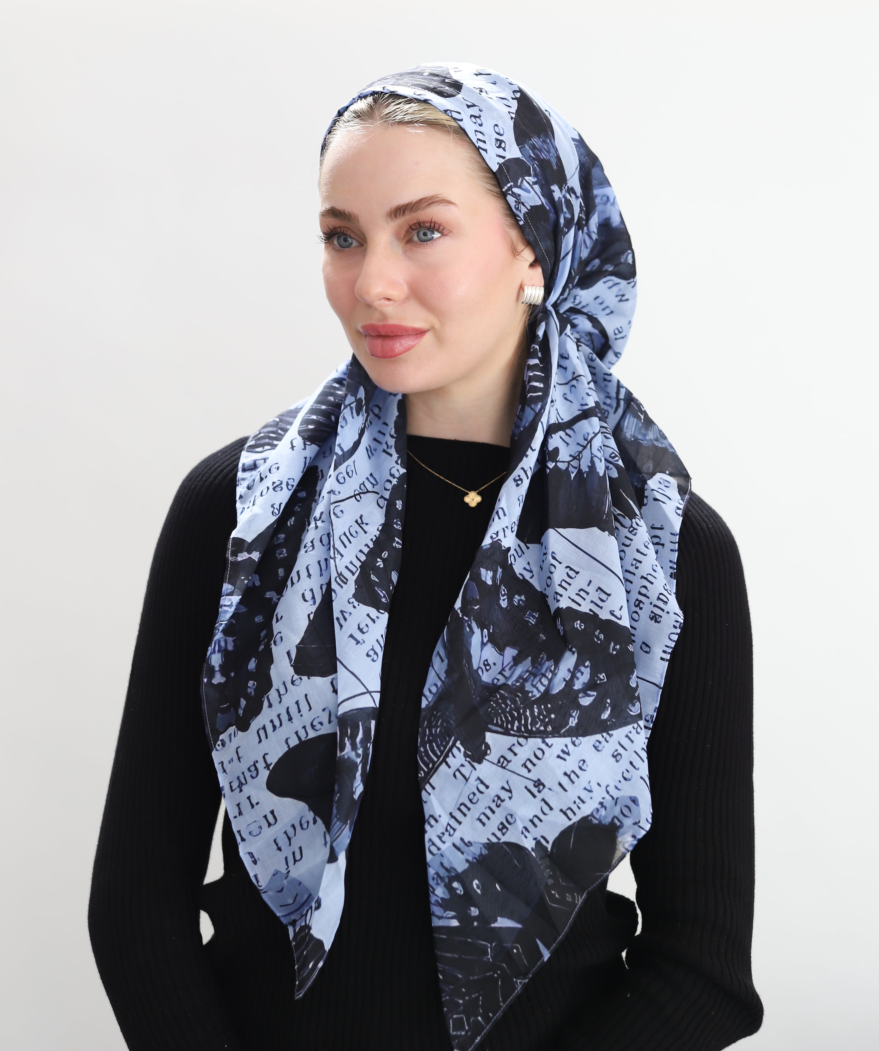 Woman wearing a patterned headscarf Typecast by TUK features a denim-blue backdrop layered with bold black butterflies and typewritten text. Graphic, cool, and instantly eye-catching.