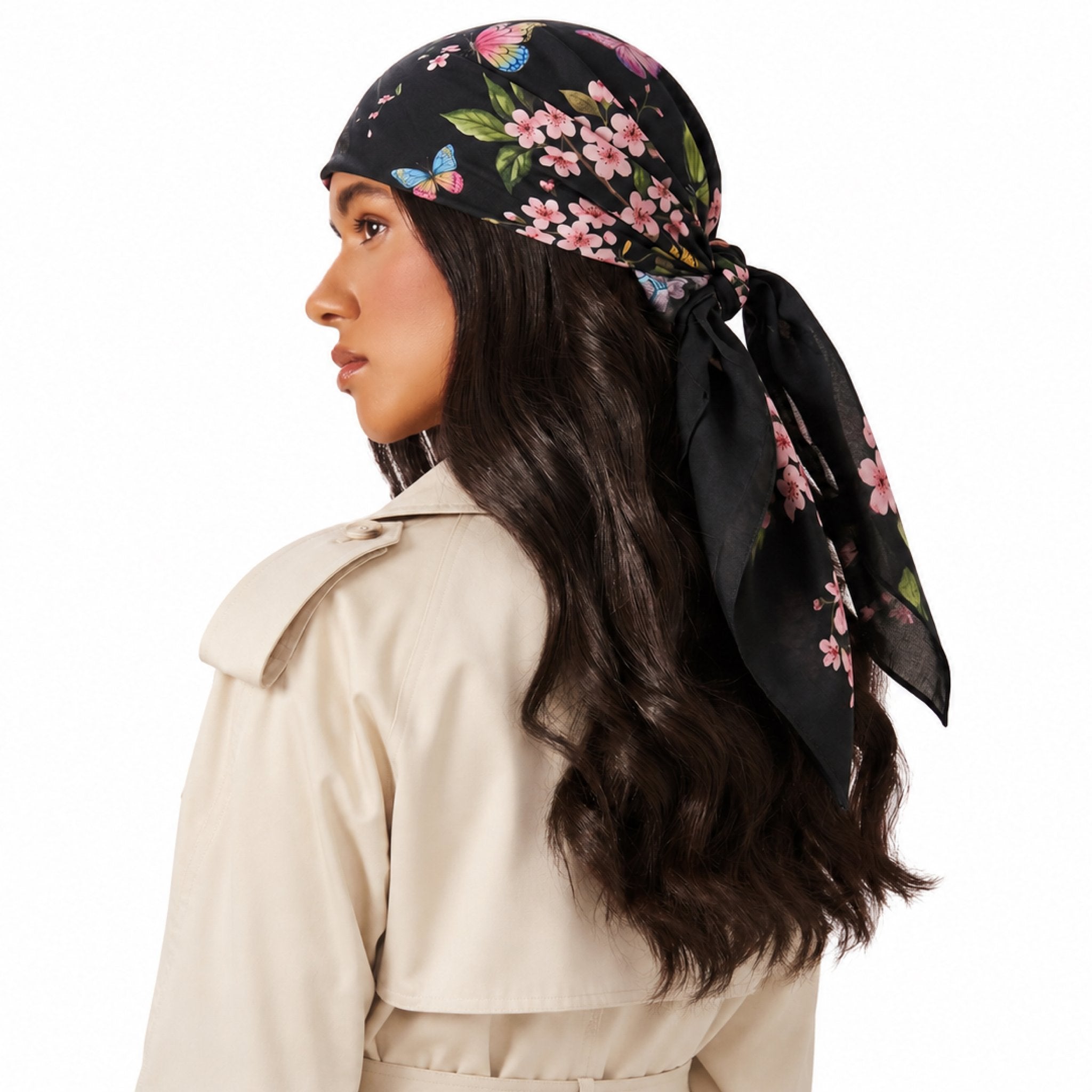 After Bloom Head Scarf in black with pink cherry blossoms and blue butterflies, worn on a woman's head.