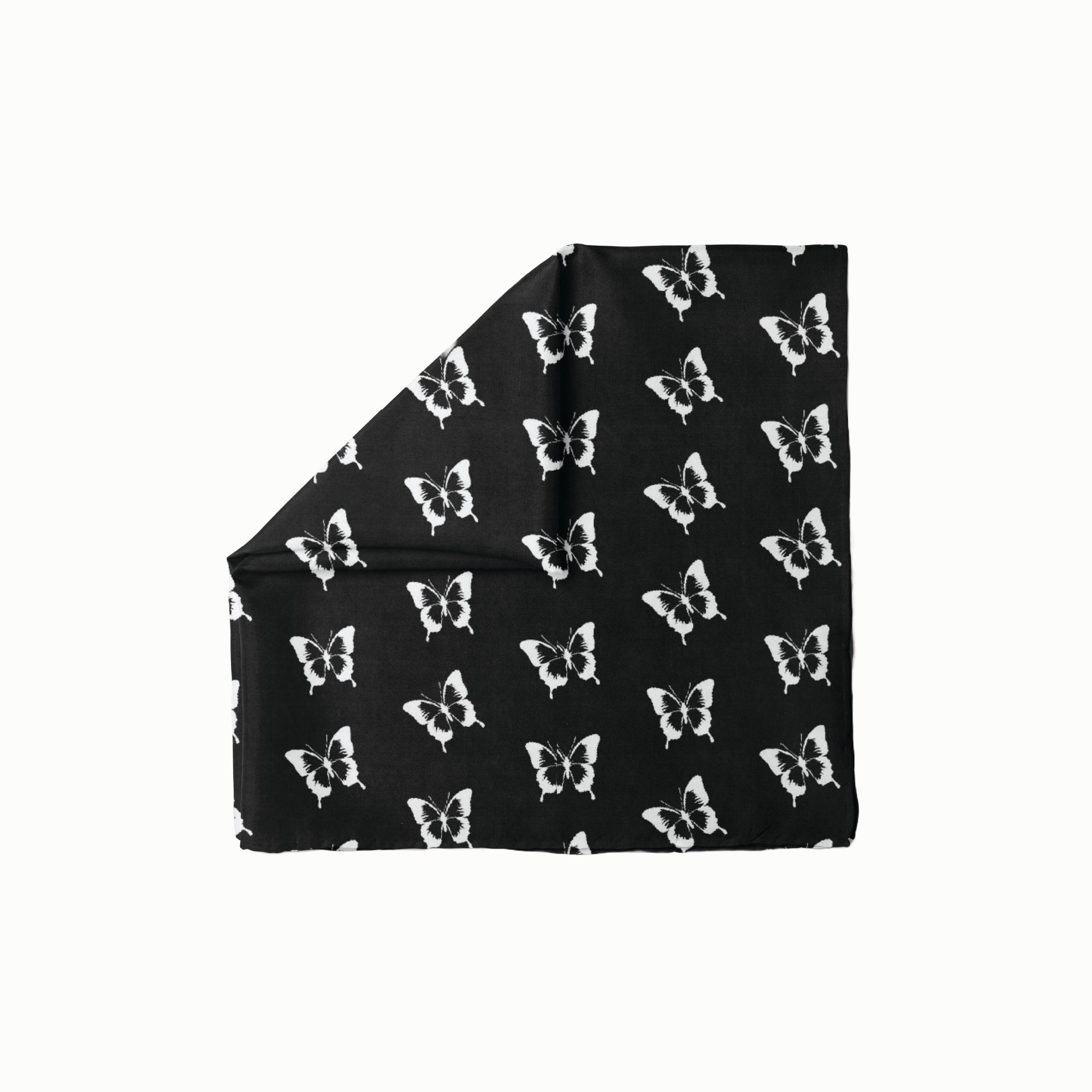 Enchanted Flight Head Scarf featuring a repeating white butterfly pattern on a solid black background, folded with one corner turned down