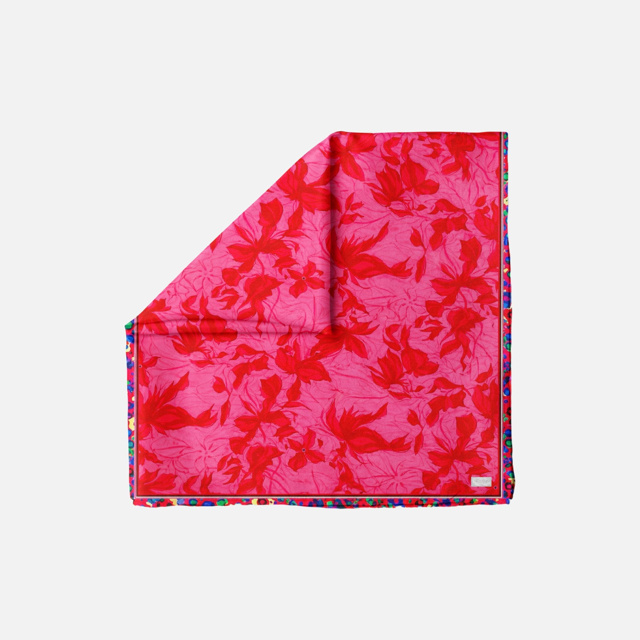Prima Ballerina Head Scarf, folded in a triangular shape, featuring a vibrant pink background with red floral patterns.