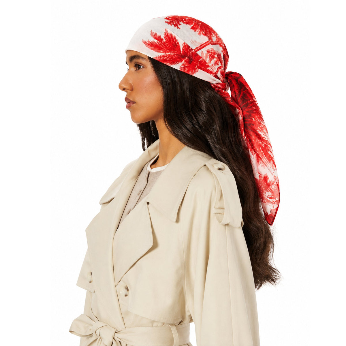 Model wearing TUK Resort To This Head Scarf with red tropical palm print, tied at the back, styled with a cream trench coat.