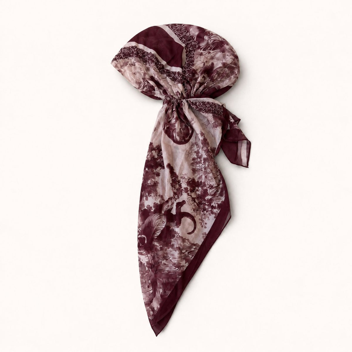TUK Untamed & Untied Head Scarf styled in a bow with burgundy wildlife and floral prints, diagonal stripes, and maroon trim.